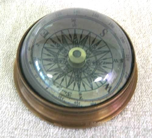 Brújula bajo cúpula arqueada de vidrio y latón antiguo. 