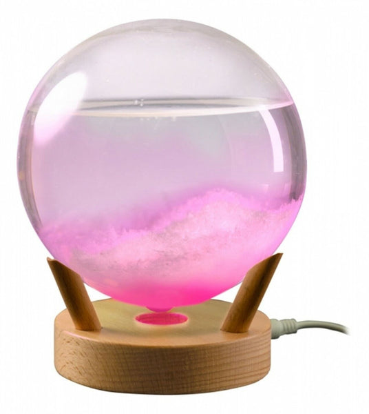 Vidrio de tormenta iluminado sobre una base de madera: juego de colores